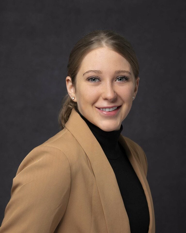 Young female executive looking at camera smiling for professional headshot