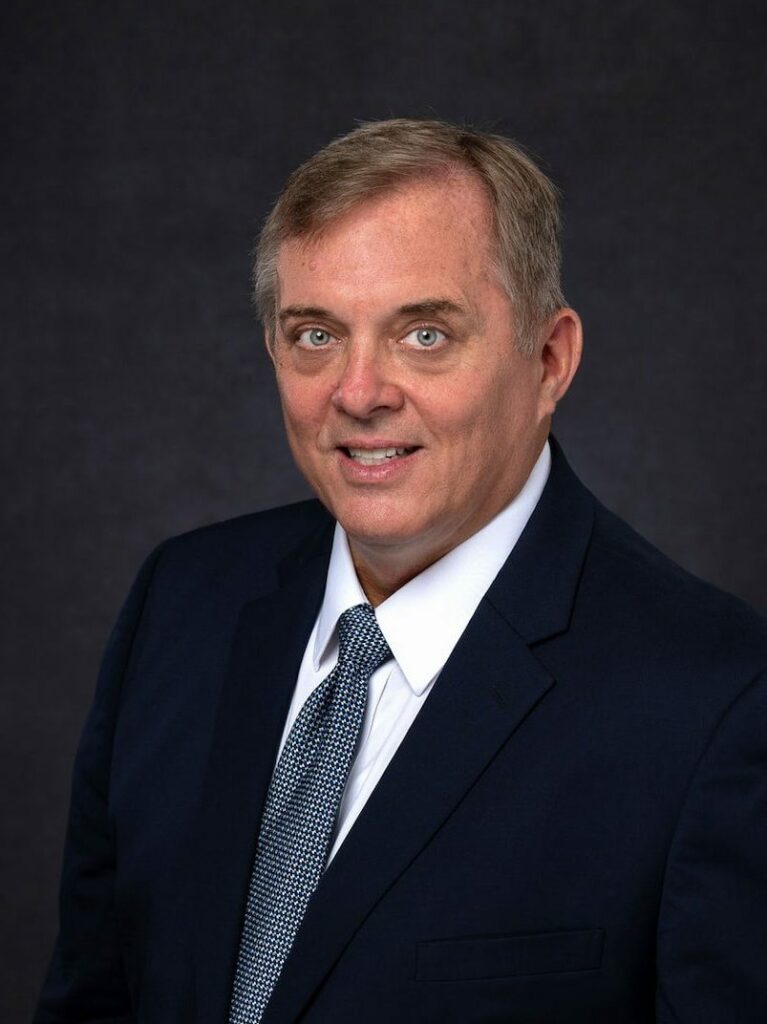 Professional headshot in a dark suit and tie