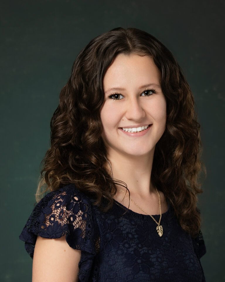 Answering your corporate headshots faqs like we did this women's wearing black shirt on a grey background