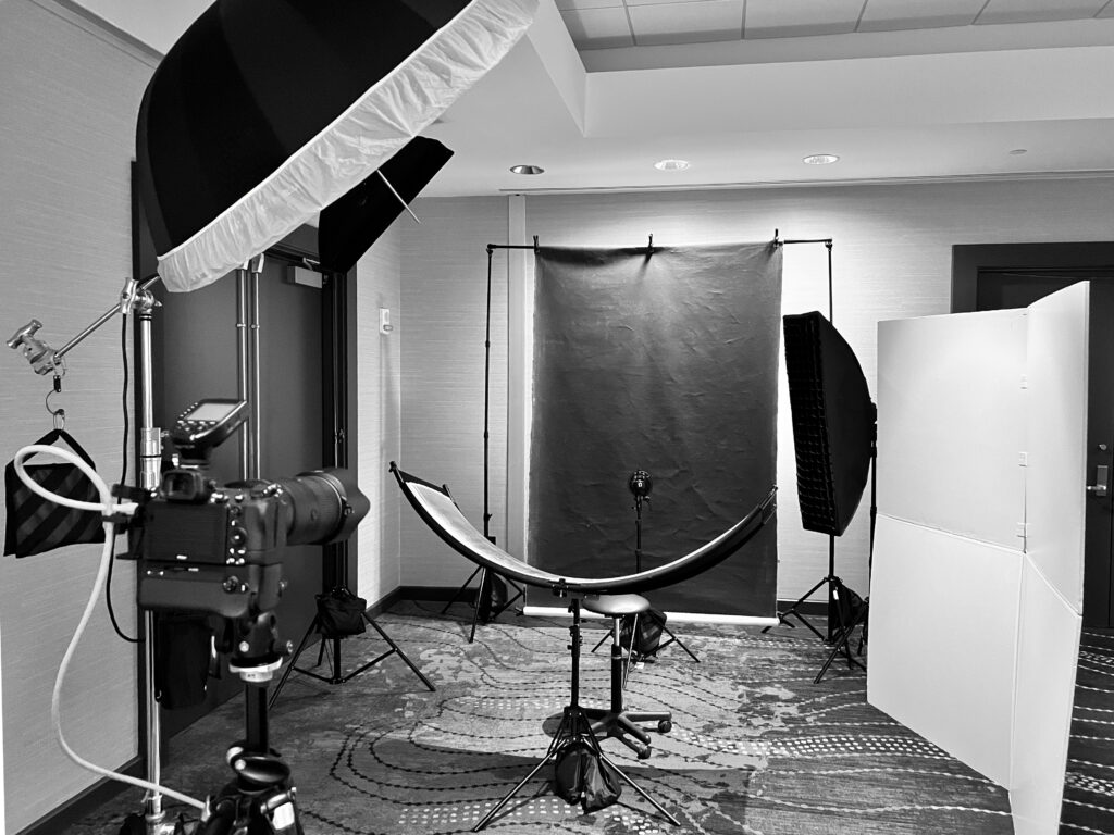 Attendee reviewing conference headshots on a tethered monitor