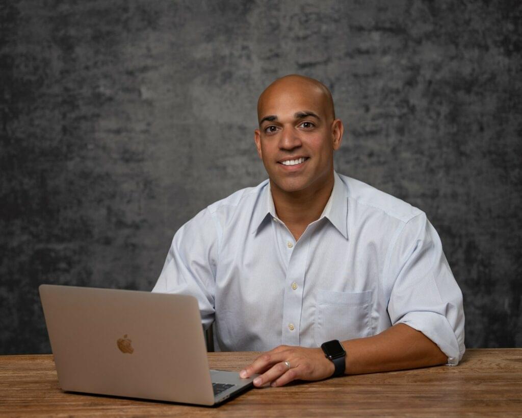 businessman open collar rolled sleeves at a desk on his computer